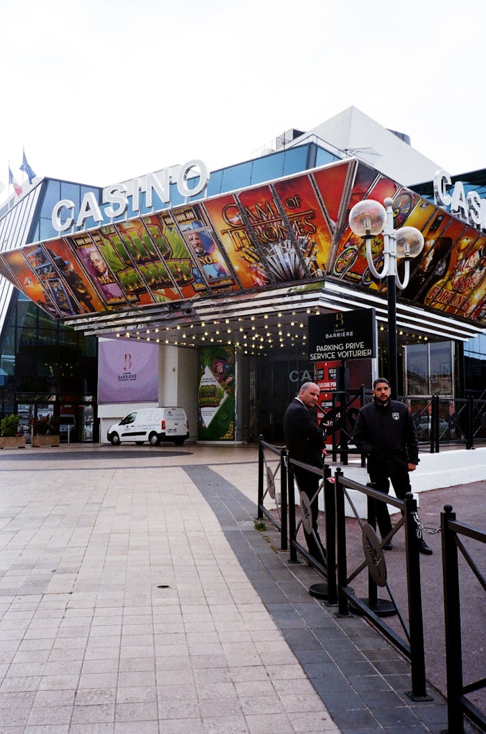 A colorful casino entrance with two security guards and decorative artwork.