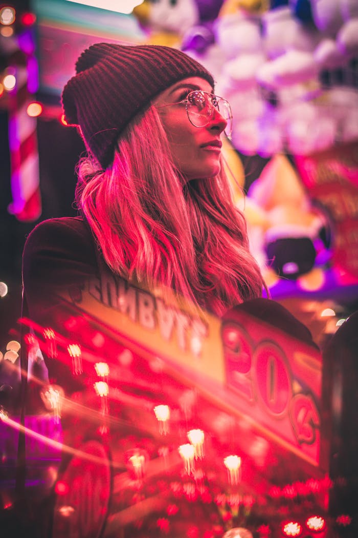 Stylish woman in urban setting with neon pink lights and casino reflections at night.